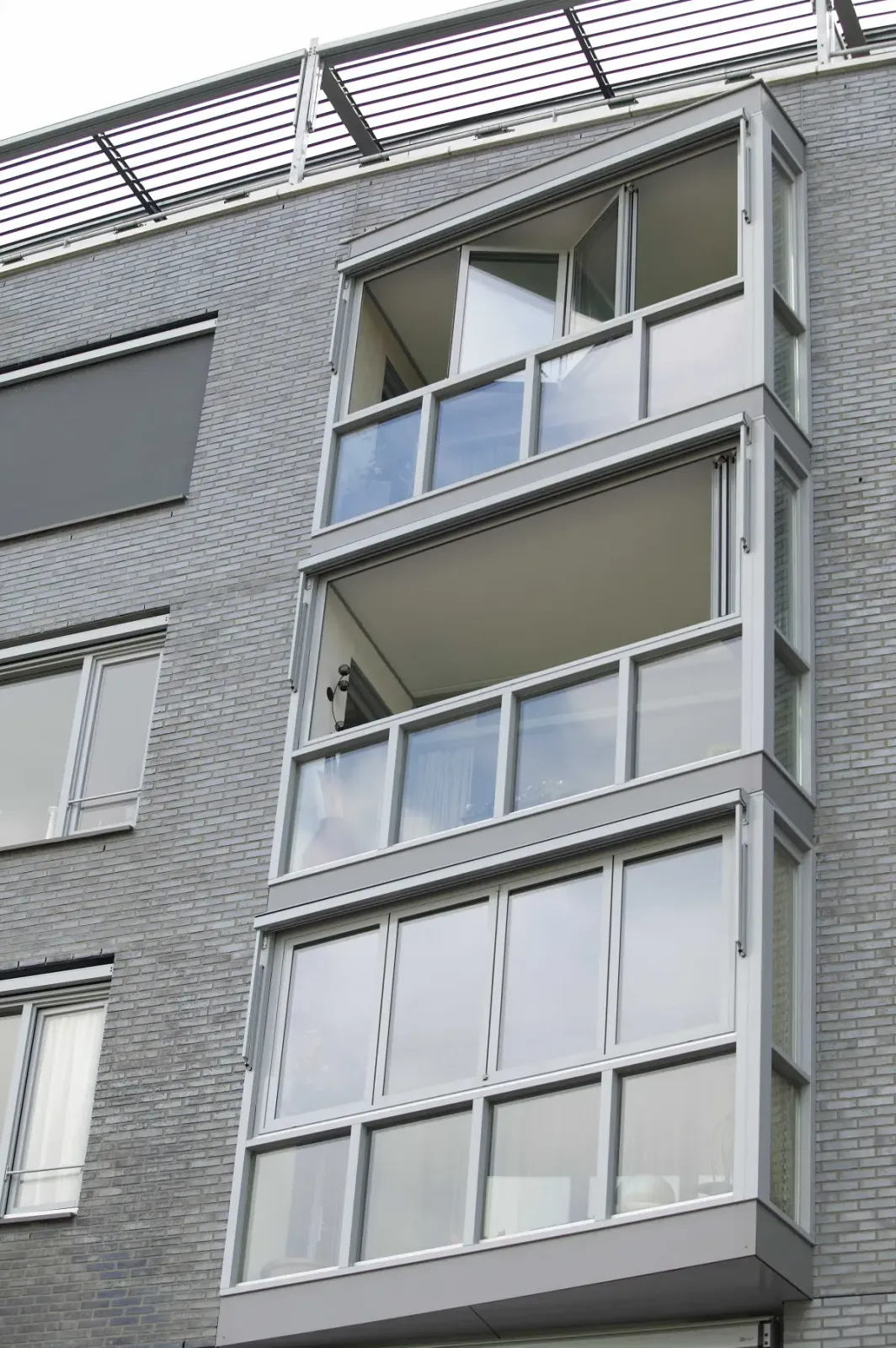 Apartman cephesinde camla kapatılmış balkonlar